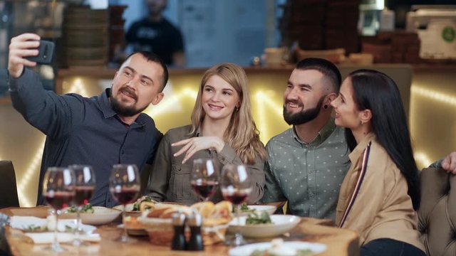 Two joyful couple taking selfie use smartphone posing together at dinner. 4k Dragon RED camera
