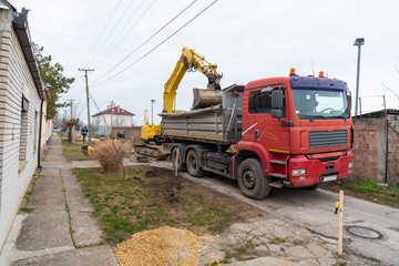 Workers with machinery preparing the road for new asphalt