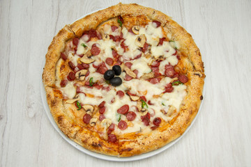 Pizza diavolo traditional italian meal from spicy salami peperoni chili onion olives and basil.
