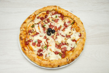 Pizza diavolo traditional italian meal from spicy salami peperoni chili onion olives and basil.