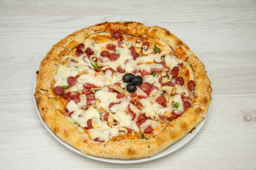 Pizza diavolo traditional italian meal from spicy salami peperoni chili onion olives and basil.