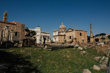 Fototapeta premium Daytime panoramic sunny photo of the ancient ruins of the Roman Forum. Scenic view on Foro Romano in Rome.