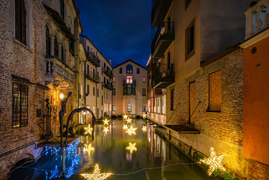 27 december 2019, Treviso (Italy): Statue and star lights on the Malvasia Canal in the city center of Treviso at sunset