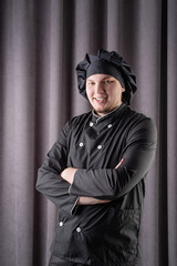 Male chef isolated on dark curtain background