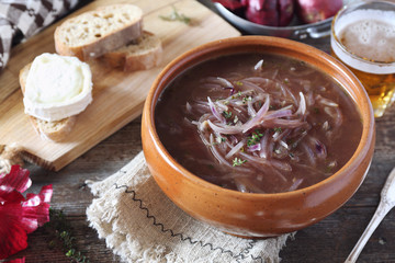 French authentic cuisine. Red onion beer soup with bread and goat cheese