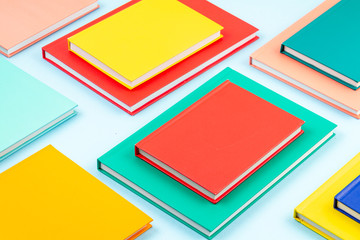 Colorful notebooks over the blue pastel background. Modern abstract working space