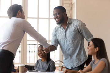 Multiracial business partners shake hands starting or accomplish business meeting