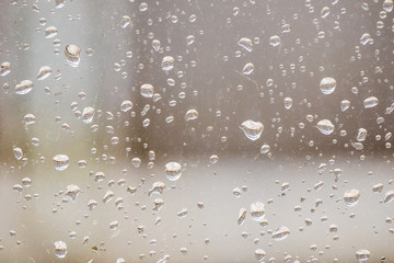 Raindrops on window glass, rainy weather, background for design_