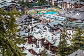 Fototapeta premium Wooden chalets and hotels in swiss village in Alps, Switzerland