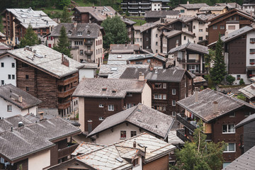 Fototapeta premium View of the roofs of chalets in a Swiss resort. A place preserving authentic architecture. Natural stone roofs, wooden facades