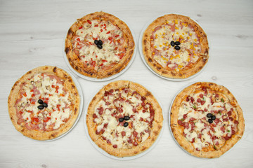 table with five types of pizza