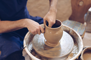 Fototapeta na wymiar Potter making a clay vase on a potter's wheel