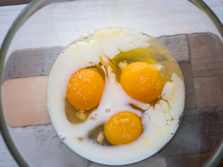 process of making omelet from natural eggs and products. Milk, salt, eggs. Cup for whipping omelet. Fork and knife. Frying pan and oil