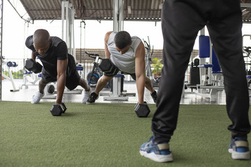 two men doing push up in the gym