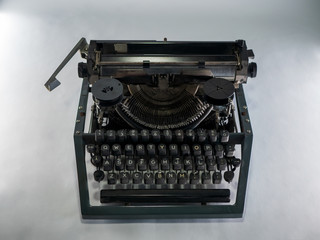 Old vintage typewriter, retro machine with white sheet of paper and typed text.