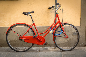 Fototapeta na wymiar old red bicycle on the wall