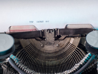 close-up typing TOP SECRET, old vintage typewriter with sheet of paper. Blood splatter. concept of bloody secrets