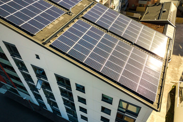 Aerial view of solar photovoltaic panels on a roof top of residential building block for producing...