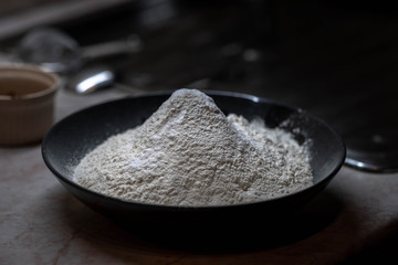 Sifting flour into bowl on table