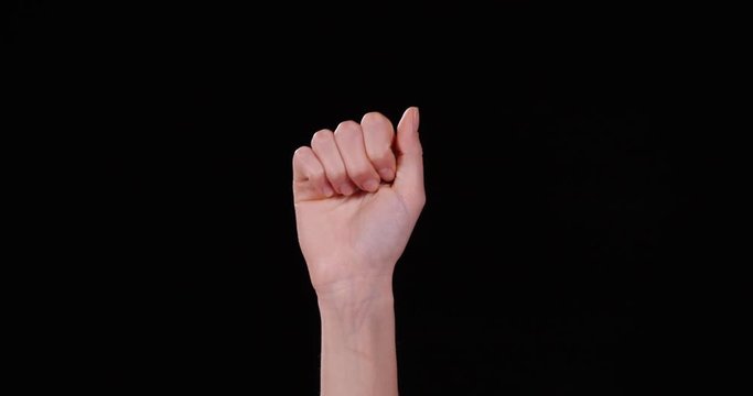 Woman showing A letter on black background, closeup. Sign language