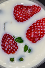 close up photo of semi-submerged strawberries on milk