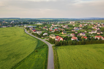 Naklejka premium Aerial landscape of small town or village with rows of residential homes and green trees.