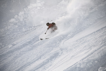 Naklejka na ściany i meble Skiier in full equipment rides on a ski in mountains