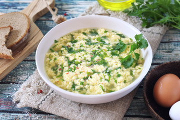 Italian food. Stracciatella soup: parsley, eggs, olive oil and parmesan cheese.