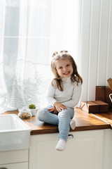 Little cute girl playing in the kitchen, happiness, family. Cooking.