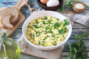 Italian food. Stracciatella soup: parsley, eggs, olive oil and parmesan cheese