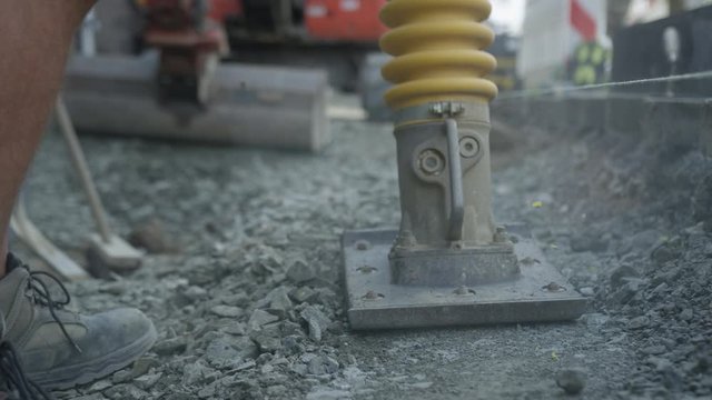 Worker on construction site with vibrating rammer