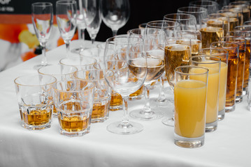Glasses with alcoholic beverages and juices close-up at the reception. Drinks