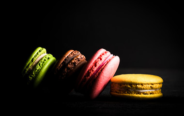 .colored macaroons on a black background