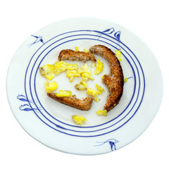 Leftover scrambled eggs and toast breakfast on plate without napkin. Isolated.