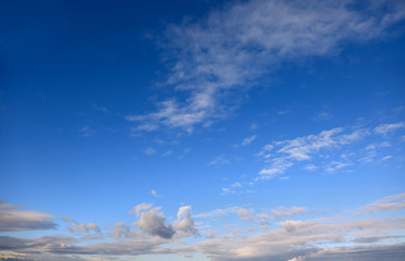 Chmury, obłoki na błękitnym niebie w czasie zachodu słońca.	