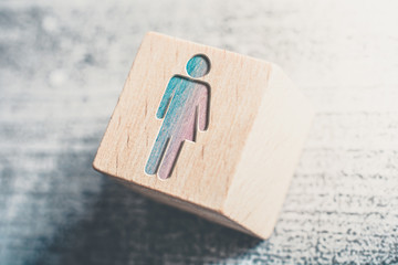 Combined Gender Signs For Male And Female On A Wooden Block On A Table