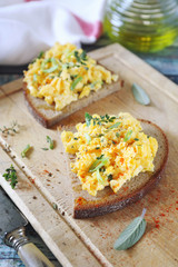 Scrambled eggs on slice of rye bread for breakfast