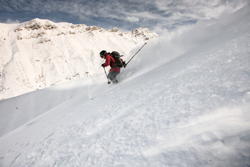 Smiling skiier gliding down the mountain side