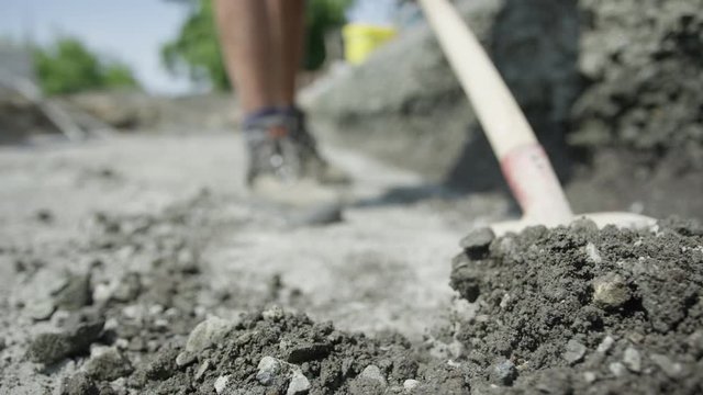 Worker shoveling away gravel dirt