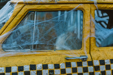Old retro yellow taxi decorated with cobwebs