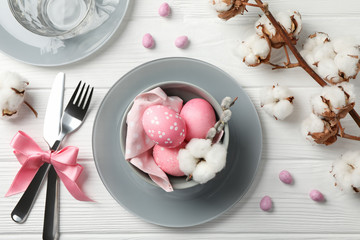 Easter table setting on white wood background, top view