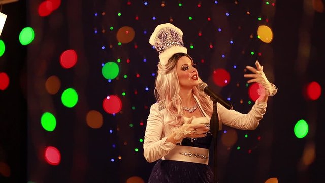 Video clip young woman singer in a New Year&rsquo;s costume Snow Maiden sings a song in stage light