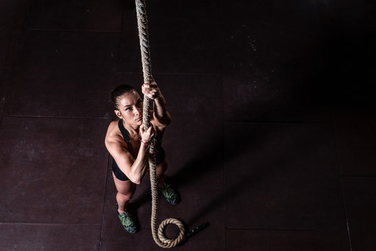 Premium Photo  Young woman gymnast on rope fitness rope climb cxercise in  gym.