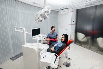 Fototapeta premium Doctor and patient look at the camera, smile health. Dentistry