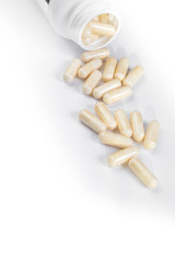 medicine bottle open with pills on white background