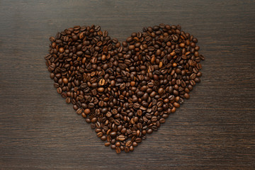 texture of coffee beans in heart shape on dark wooden surface