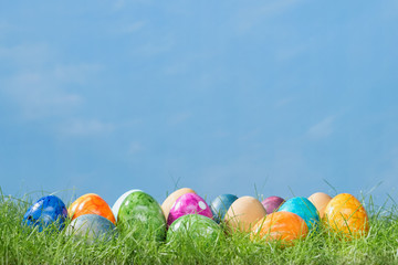 Easter eggs in spring grass with cloudy sky