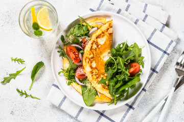 Omelette with green leaves top view.