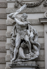 Sculpture of Hercules with a raised mace fighting a hydra that is entangled in Vienna, Austria.