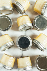 Homemade honey butter in glass jars on marble background